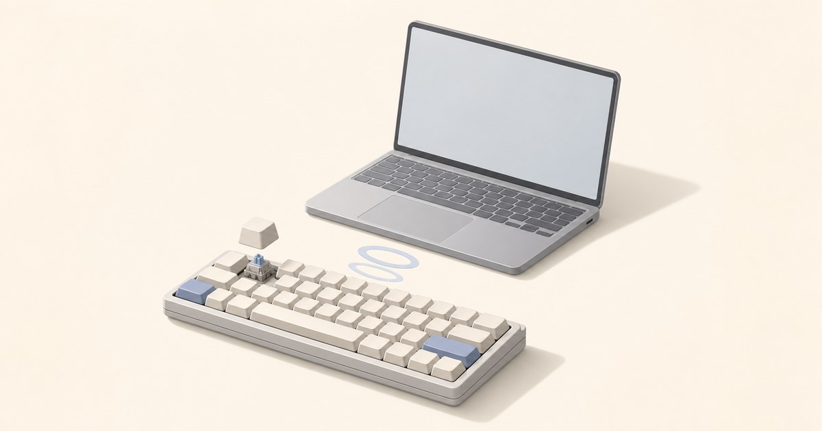 Cream compact mechanical keyboard with blue accent keys and a lifted keycap showing its switch, beside a silver laptop with a wireless icon between them.